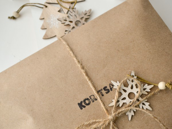 packaged holiday letter with twine and wooden ornaments